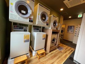 a laundry room with three washing machines and a washer and dryer at Hotel Route-Inn Fujieda-Eki Kita in Fujieda