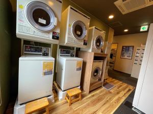 uma lavandaria com três máquinas de lavar roupa e uma máquina de lavar e secar roupa em Hotel Route-Inn Fujieda-Eki Kita em Fujieda