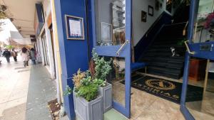 a blue building with potted plants next to a staircase at Hotel Asturias in Viña del Mar