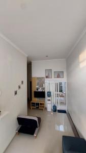 ein Wohnzimmer mit einem Bett und einer Küche in der Unterkunft Noosa Villa - Kota Batu in Batu