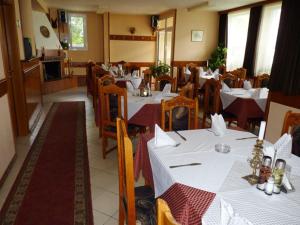 ein Restaurant mit Tischen und Stühlen mit weißem Tischtuch in der Unterkunft Niko Hotel in Samokow