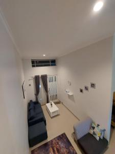 ein Wohnzimmer mit einer Couch und einem Sessel in der Unterkunft Noosa Villa - Kota Batu in Batu