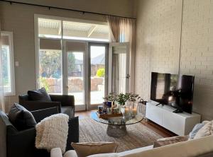 a living room with a tv and a couch and a table at The Loft Barossa in Angaston
