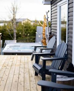 Duas cadeiras e uma mesa num deque com piscina em Unique & Private Waterfront Lake Cottage with Luxury Hot Tub em Grand River