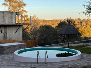 a swimming pool in a yard with an umbrella at La Caballeriza Hostel in Tanti Nuevo +47 photos