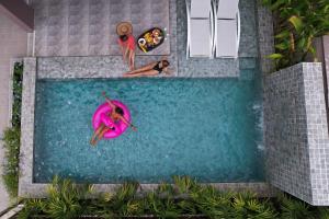 a swimming pool with two people in the water at Southern Peak Pool Villa Huay Yai Pattaya in Ban Huai Yai