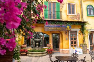 a building with a table and chairs and flowers at Hoàng Hôn Tím Boutique Hotel in Phú Quốc +53 photos