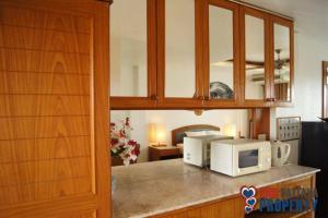 a kitchen with a counter top with a microwave at 2 Somphong Ban Amphur Beach Thailand Condotel in Na Jomtien