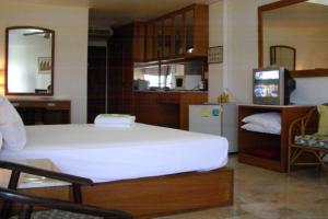 a bedroom with a large white bed and a television at 2 Somphong Ban Amphur Beach Thailand Condotel in Na Jomtien