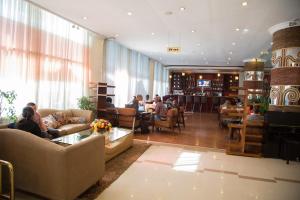 a lobby with people sitting at tables in a restaurant at Jupiter International Hotel - Bole in Addis Ababa