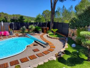 a swimming pool in a backyard with a blue pool slide at Julias in Draguignan