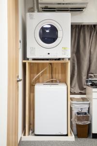 Um micro-ondas e uma máquina de lavar roupa na cozinha em NewOpen/Stella Izumisano/泉佐野駅徒歩3分【一棟貸切】関西空港まで 8分 em Izumi-Sano