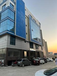 un grande edificio con macchine parcheggiate di fronte di NuvaHotel a Islamabad