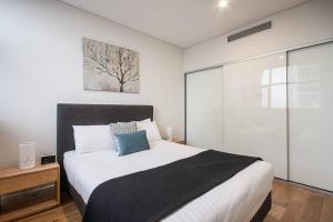 悉尼Macquarie Park corporate one bedroom Moo05807的卧室配有一张床,墙上挂着一幅树画
