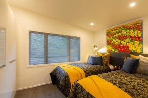 a bedroom with two beds and a painting on the wall at Amazing Lake Views in Queenstown