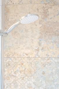 a shower head in front of a stone wall at Zeiserhof in Ramsau am Dachstein