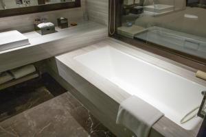 Crowne Plaza Kunshan, an IHG Hotel في كونشان: حمام مع حوض وحوض استحمام