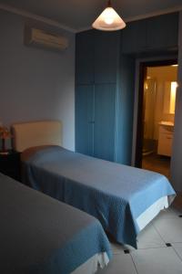 1 dormitorio con 2 camas y armarios azules en Ithaki Holidays, en Lefkada
