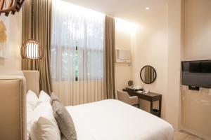 a hotel room with a bed and a television at Girasol Tagaytay in Tagaytay