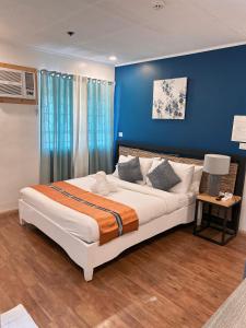 sypialnia z dużym łóżkiem z niebieskimi ścianami w obiekcie The New View by Ecotel w mieście Iloilo