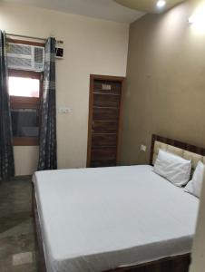 a bedroom with a large white bed and a window at Vishal AC homestay in Rāja Sānsi