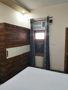 Schlafzimmer mit einem Bett und einem Fenster in der Unterkunft Vishal AC homestay in Rāja Sānsi