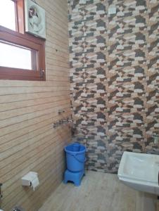 uma casa de banho com um WC azul e um lavatório. em Vishal AC homestay em Rāja Sānsi
