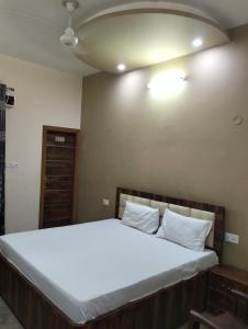 a bedroom with a large bed with white sheets at Vishal AC homestay in Rāja Sānsi