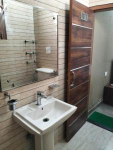 a bathroom with a sink and a mirror and a shower at Vishal AC homestay in Rāja Sānsi