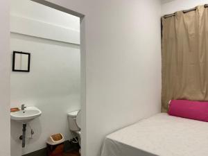 a small bathroom with a bed and a sink at Hostal Crisangel in Rivas