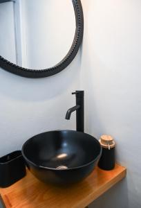 a bathroom with a black sink and a mirror at Boucaporta Sirma Klima in Klima