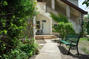 a green bench sitting outside of a house at Giselle Apartment in Budapest