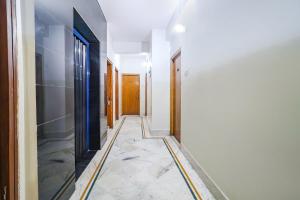 a hallway with a tile floor and doors at FabHotel Nand in Patna