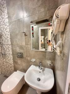 y baño con lavabo blanco y espejo. en Green Cape Tower en Batumi