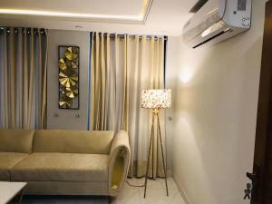 a living room with a couch and a lamp at Eiffle Tower View Apartments in Rāmkot
