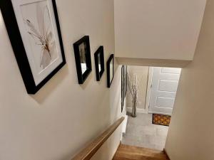 a hallway with three pictures on the wall at Modern Vac Home, private Hot tub, close to airport in Moncton +14 photos