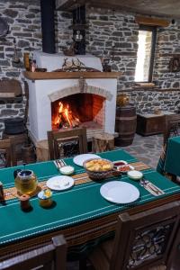 a table with plates of food and a fireplace at GUEST HOUSE ELENA in Kosovo