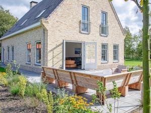 OosterendにあるVilla on Texel near Wadden Sea & Bird Areaのレンガ造りの家の前にある大きなデッキ