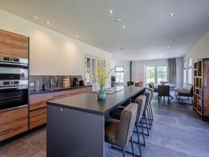 OosterendにあるVilla on Texel near Wadden Sea & Bird Areaの長い島(椅子、カウンター付)のあるキッチン