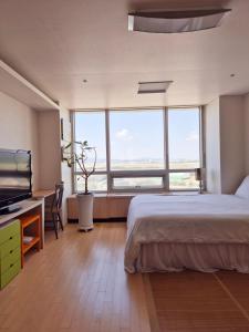 sypialnia z łóżkiem i dużym oknem w obiekcie Cozy Bright Studio w mieście Inczon