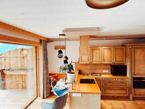a kitchen with wooden cabinets and a table and chairs at Zottlhoamat in Matrei in Osttirol