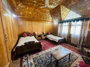 a room with two beds and a table in a room at Maharaja palace houseboat in Srinagar