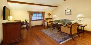 ein Wohnzimmer mit einem Sofa und einem Tisch in der Unterkunft The Oberoi Cecil in Shimla