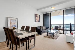 a living room with a table and chairs and a couch at Urban Skyline 2-Bed with Pool & Gym Access in Brisbane