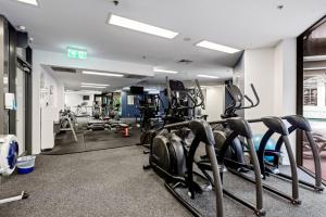 a gym with treadmills and elliptical machines at Urban Skyline 2-Bed with Pool & Gym Access in Brisbane