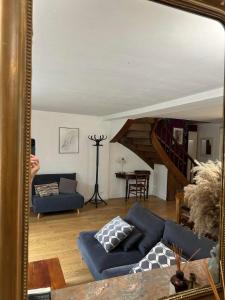 una persona que toma una foto de una sala de estar con espejo en Maison au calme avec terrasse et jardin, en Chinon