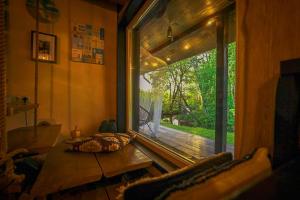 a room with a large window with a view of a deck at River House in Nītaure