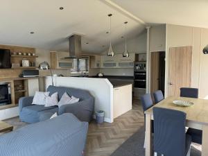 a kitchen and living room with a couch and a table at Fable Lodge Tattershall Lakes - luxury lakeside lodge with hot tub in Tattershall