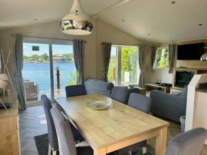 a living room with a wooden table and chairs at Fable Lodge Tattershall Lakes - luxury lakeside lodge with hot tub in Tattershall