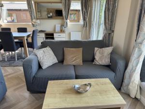 a living room with a couch and a coffee table at Fable Lodge Tattershall Lakes - luxury lakeside lodge with hot tub in Tattershall